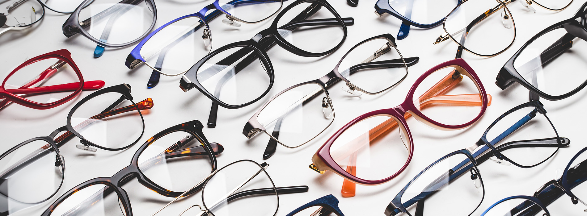 Eyeglasses with various frames and colors displayed on a white background.