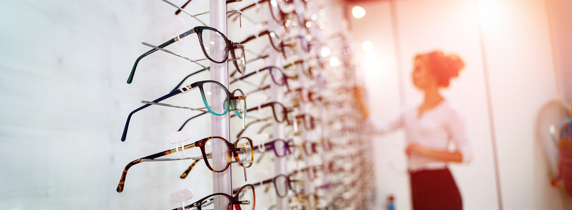 An array of eyeglass frames displayed in a store, with a focus on the variety and organization of the products.