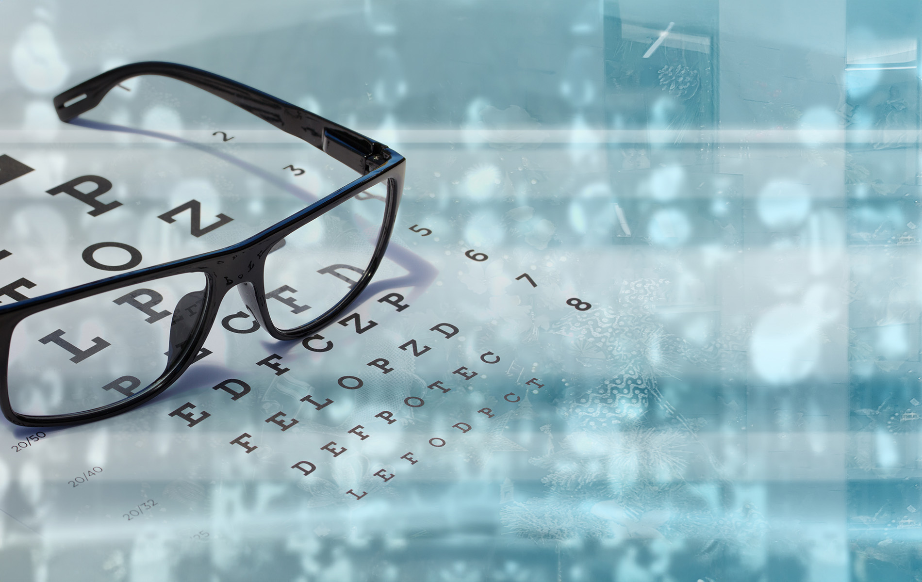 A pair of glasses with a magnified lens displaying the alphabet in Braille, placed on a surface with a blurred background.