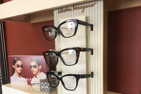 A display of sunglasses on a shelf in a store.
