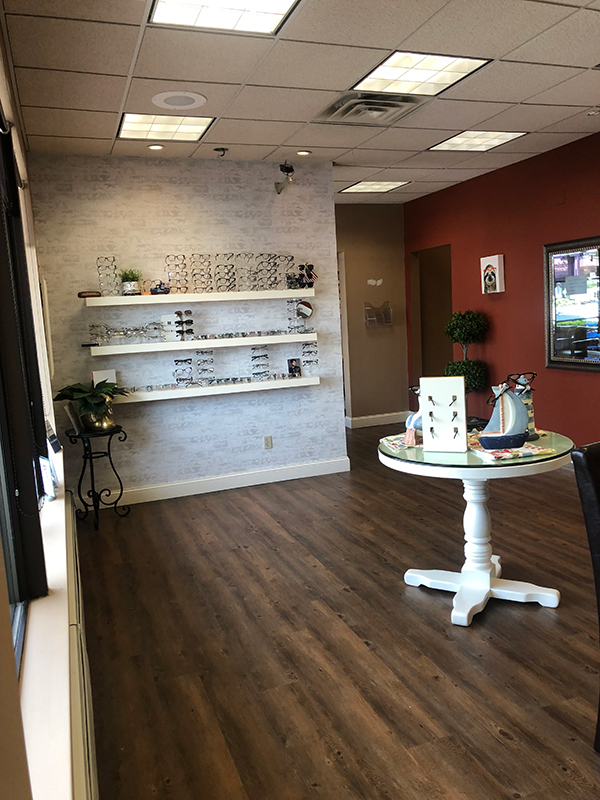 An interior view of a modern, well-lit optical store with various eyewear displays and a clean, organized layout.