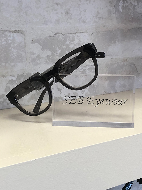 Eyeglasses displayed on a white countertop with a black frame.
