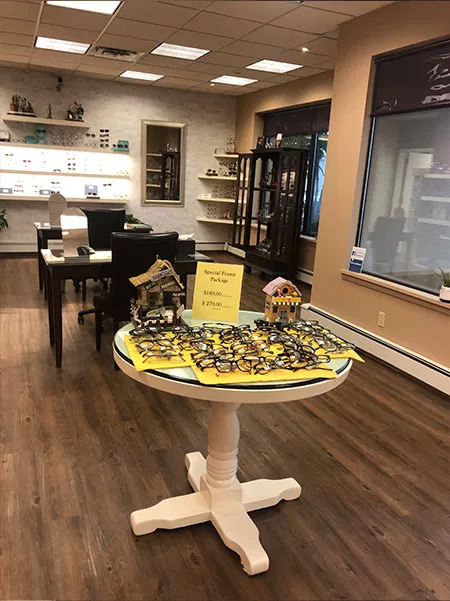 The image shows an interior space that appears to be a store or boutique, with a display table featuring items for sale and a sign indicating  Sale Items,  set against the backdrop of a retail environment with shelves and merchandise.