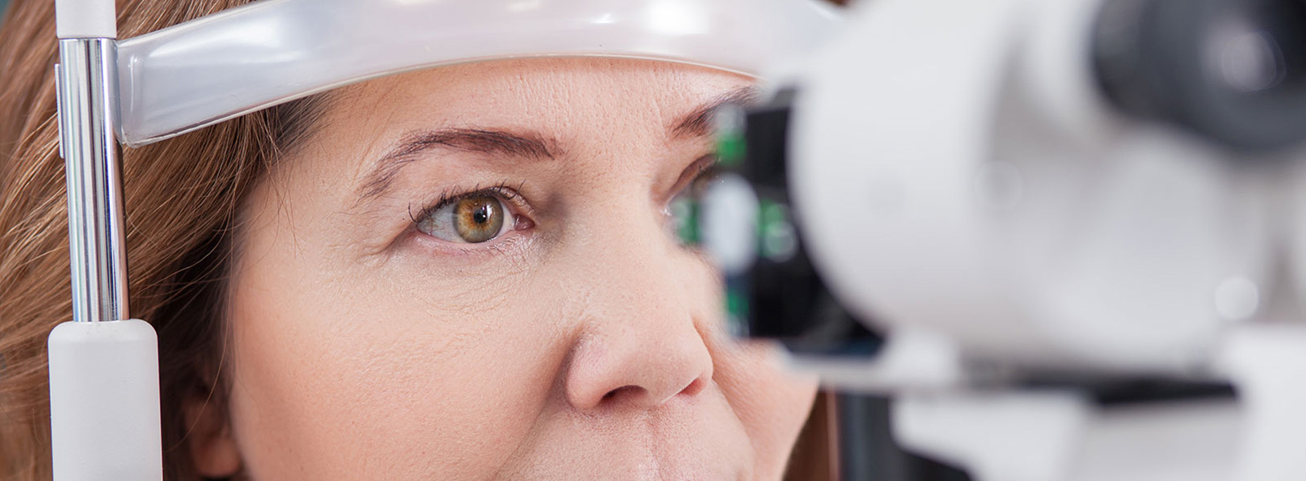 An individual with a medical device, likely an eye exam machine, in the foreground.