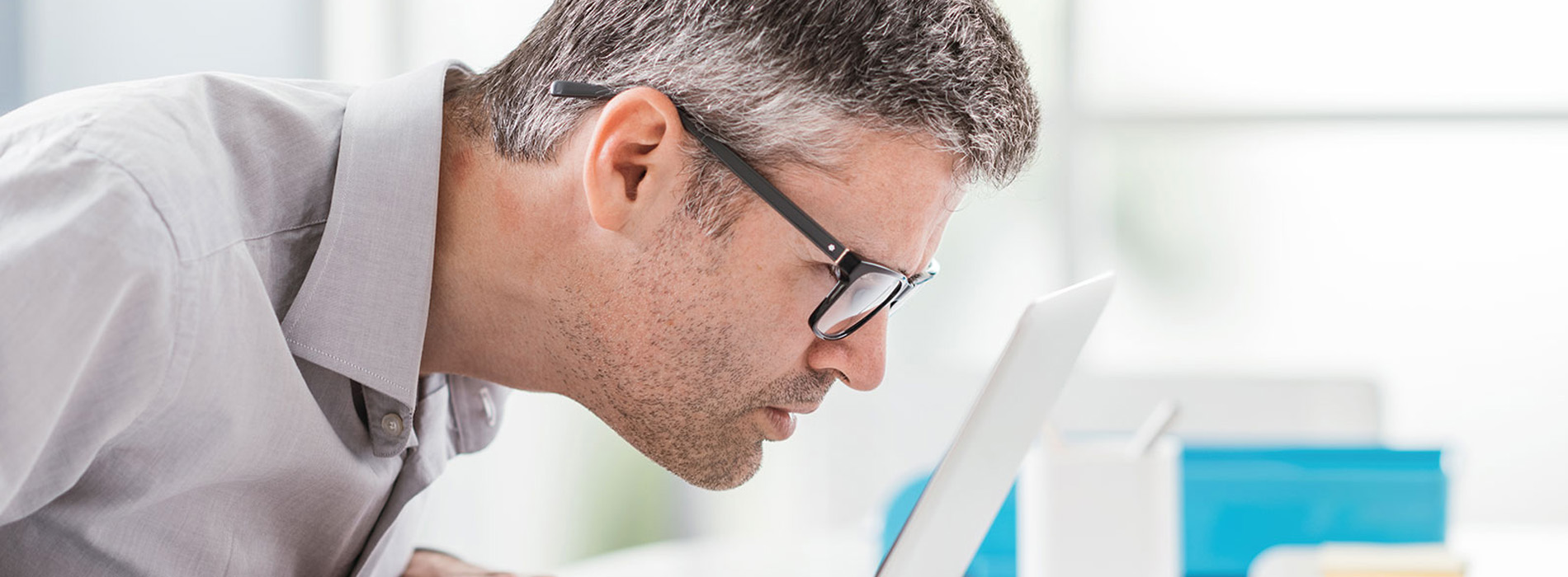 Man in glasses, working at a desk.